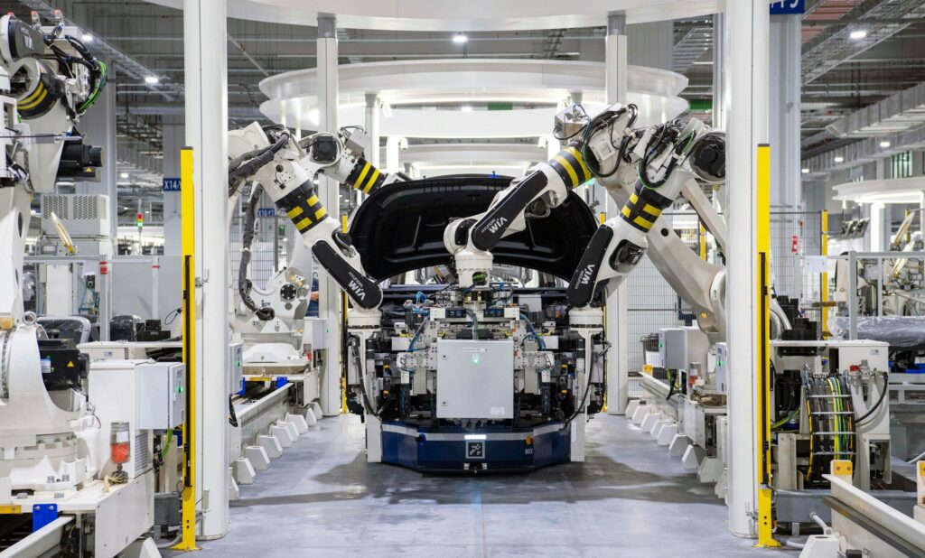 High-tech robots assembling a car in a modern factory setting, showcasing automation.